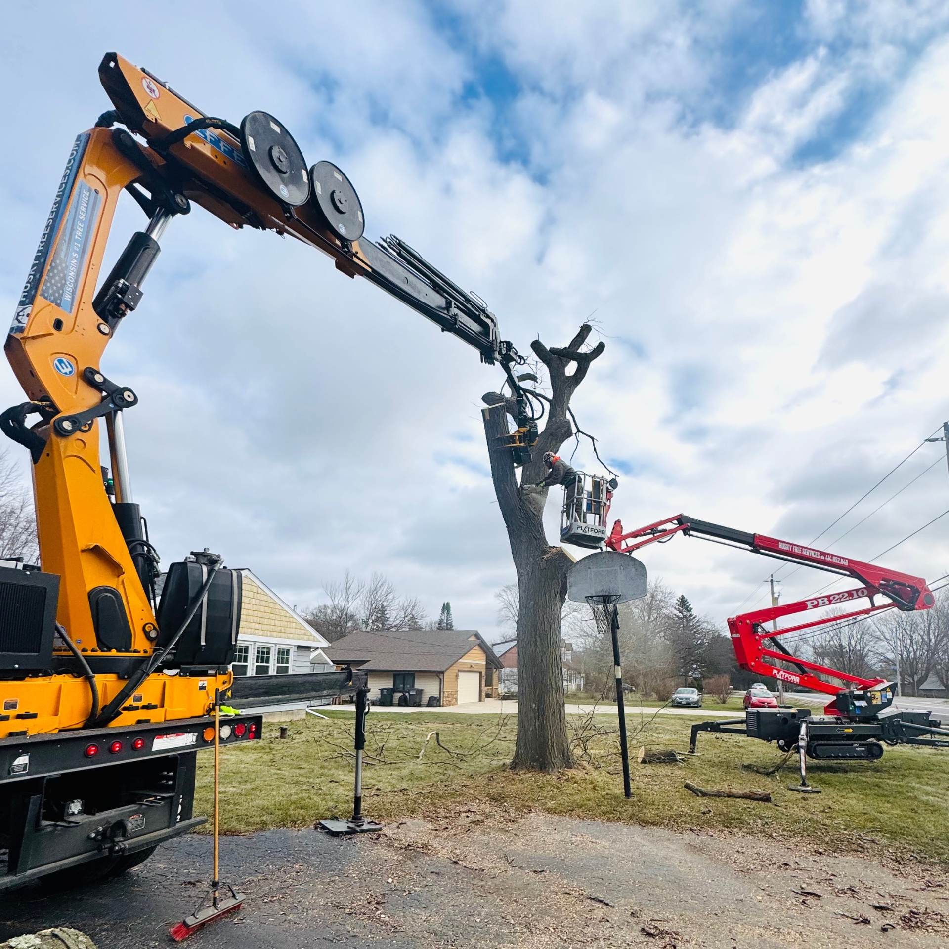 Grapple saw truck and chip truck at a Husky Tree Services job in Waukesha County